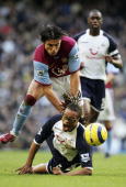 Edgar Davids is brought down by Milan Baros, as Spurs skipper Ledley King looks on in the background